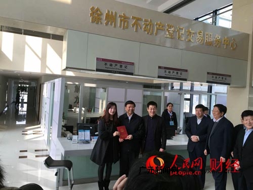 国土资源部部长姜大明（中）给邢卫锋夫妇颁证。